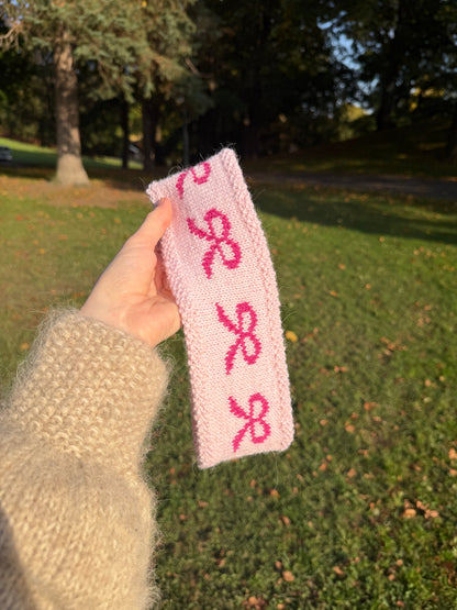lys rosa pannebånd som vises med mørk rosa sløyfer og skog i bakgrunnen